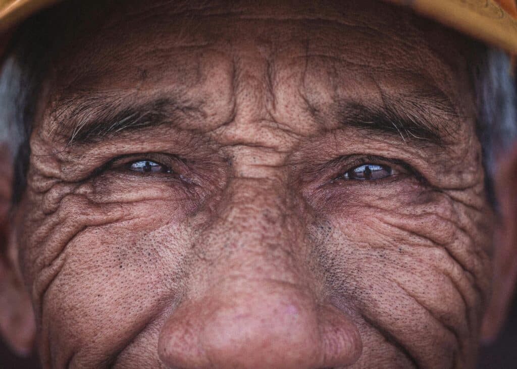 Primer plano del rostro curtido y sonriente de una persona mayor